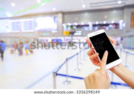 Hand holding mobile phone with airport terminal blurred  background, Bokeh light, Social network, internet,Traveling concept