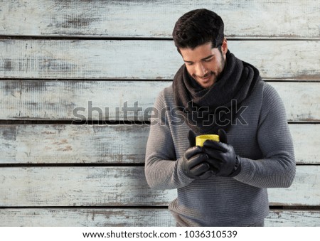 Digital composite of Man against wood with warm scarf and gloves and jumper