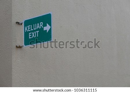 Green signboard written with EXIT or KELUAR in malay language with copy space for text or logo.