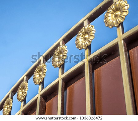 Metal gate details against the blue sky