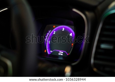 Electronic tachometer. Electronic speedometer. Digital dashboard in car. LED dashboard in automobile.  Royalty-Free Stock Photo #1036328944