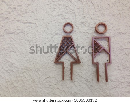 Toilet sign on white wall made from metal