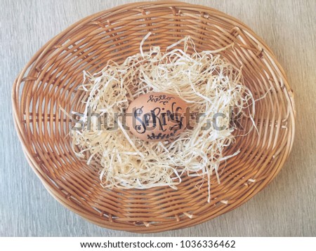 Handlettered egg in a wicker basket for Easter celebration