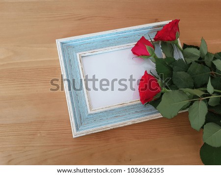 Red roses laying on a vintage frame, Love, Holiday, Wooden table