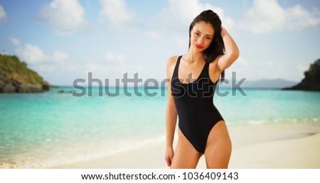 A Latina woman poses for a portrait on the beach