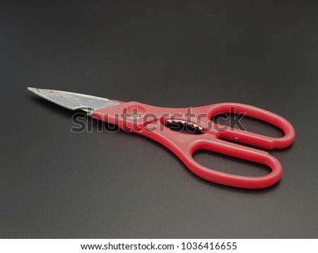 red scissor is on the black background