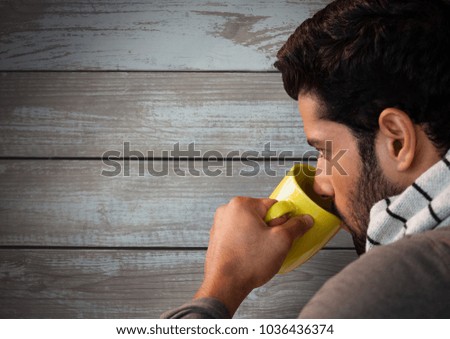 Digital composite of Man against wood with cup and warm scarf