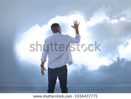 Digital composite of Businessman touching illuminated clouds
