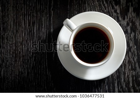 White Cup of black hot coffee on dark wooden background