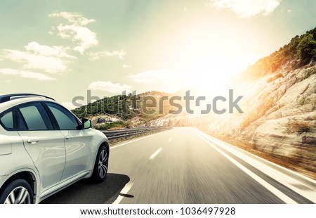 White car rushing along a high-speed highway. Toned photo. Royalty-Free Stock Photo #1036497928
