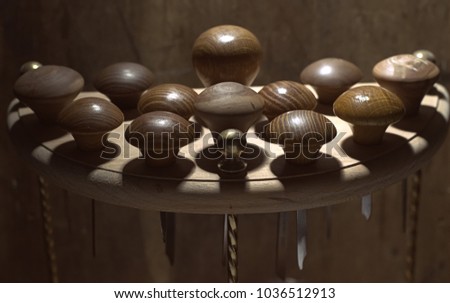 Jewelery tools: gravers at jeweler's workplace, brown background with a wooden structure, circle