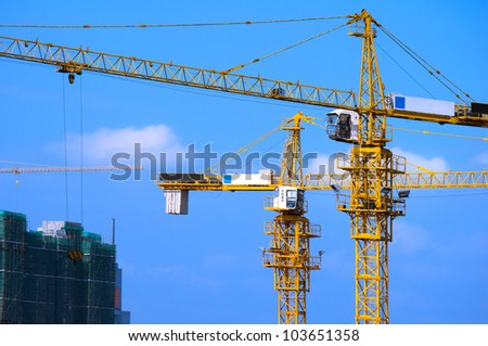 Cranes on construction site under blue sky