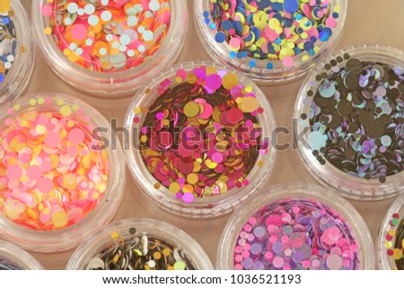 Multi colored Sequins for the design of nails in a Jar. Glitter in jars. Foil for nail service. Photo set. Sparkling beauty shimmer, glitter. Bright background of glitter. Top view.