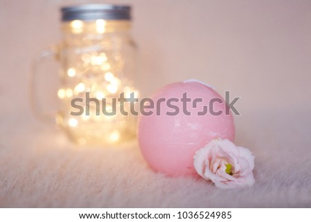 Flower on a pink background. Eustoma. pink rose. Candle. A tender flower on a candle. bank with a garland. garland. lights. lights on the background