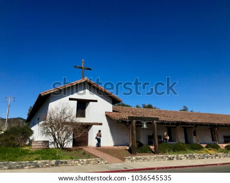 Mission San Francisco Solano in Sonoma California. Daytime color photo horizontal, copy space in blue sky, couple of unrecognizable people next to mission. 