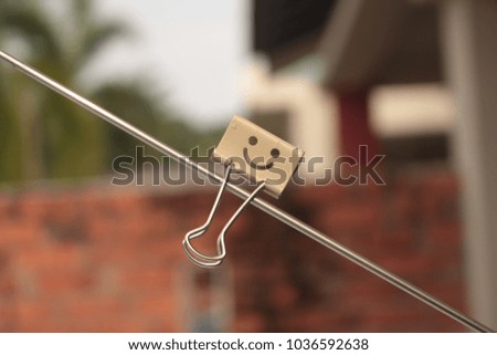 a single happy face paper clip with blurred background. 