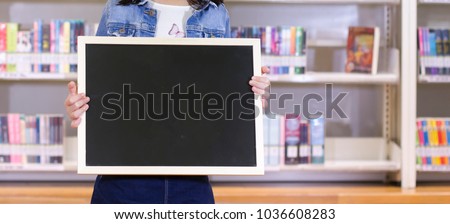 Back to school - schoolgirl and space for text. Hands holding blackboard
