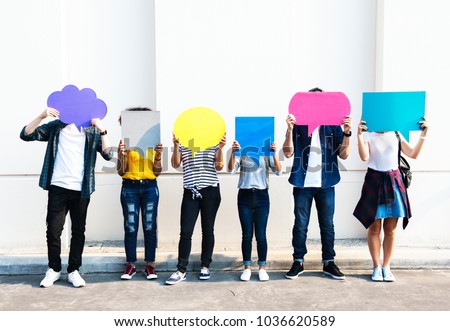 Young adult friends holding up copyspace placard thought bubbles Royalty-Free Stock Photo #1036620589