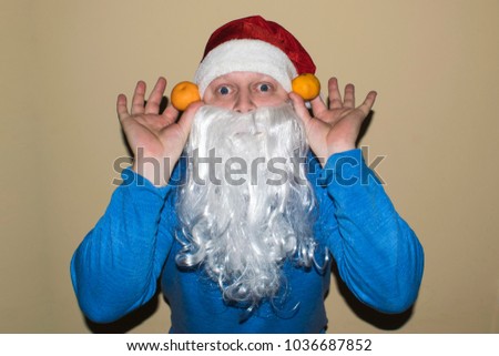 Santa Claus and a lot of two mandarins in their hands. Santa listens and extends