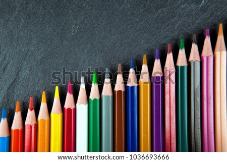 Colored pencils on a black stone slate
