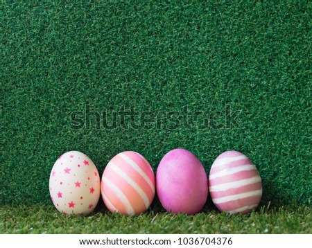 Cute pink color theme Easter eggs with stripes, marble, line and stars pattern painting eggs on green grass floor and green grass wall for copy space with Spring and Easter concept