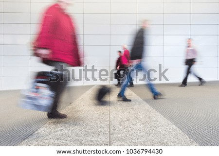 blurred commuters in a modern corridor