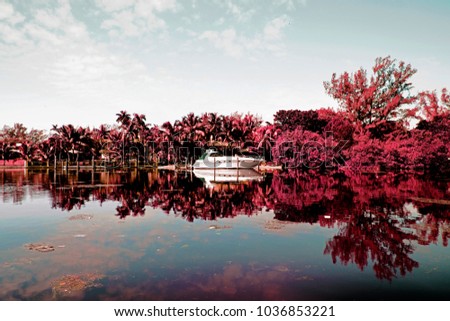 Infrared photography of a river and a motorboat and landscape in Miami Beach, Florida, USA

