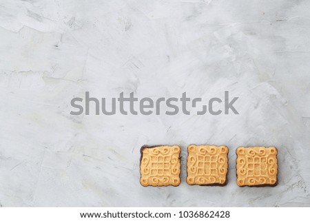 Square biscuits arranged in pattern on light textured background, close-up, shallow depth of field, selective focus.