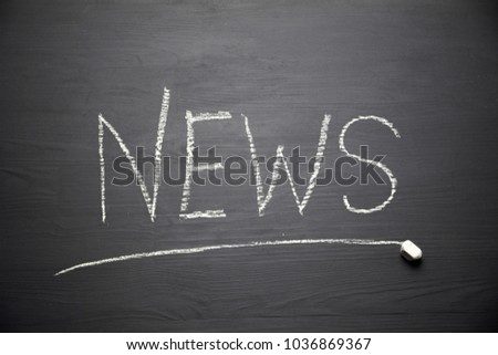 Inscription "News"  drawn in white chalk on a black chalkboard