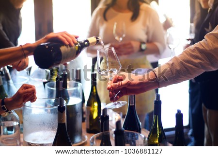 The waitress was pouring a glass of wine. In celebration of the team's success. Royalty-Free Stock Photo #1036881127