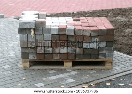 Construction of the road. The new tiled sidewalk, the blocks are signed, numbered. Industrial summer and autumn background 