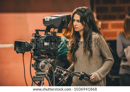 Behind the scene. Female cameraman shooting the film scene with camera in film studio Royalty-Free Stock Photo #1036941868