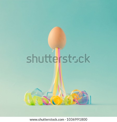 Egg with party streamers. Easter minimal concept.