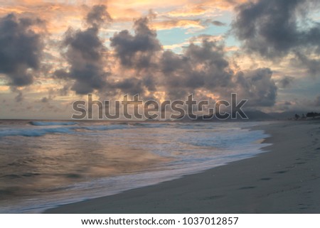 Sunset shining on high clouds at Barra da Tijuca beach
