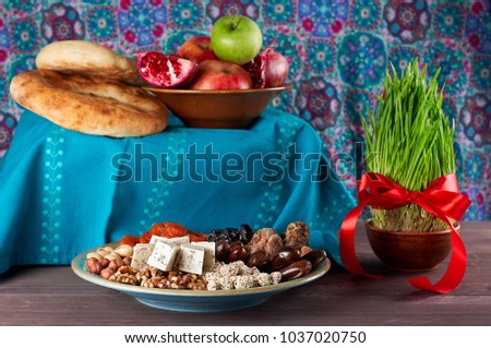 Traditional Azerbaijan sweet cuisine of holiday Nowruz: national dessert called Sumalak, lavash bread, halva, assortment of nuts and dry fruits. Fresh green grass samani symbol of spring