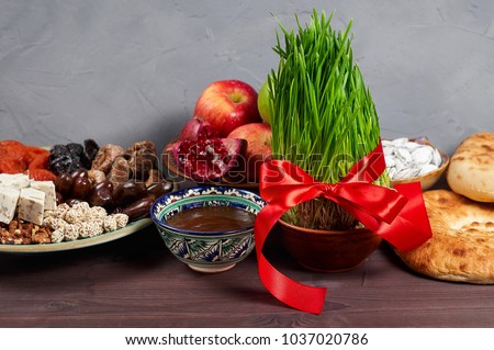 Traditional Azerbaijan sweet cuisine of holiday Nowruz: national dessert called Sumalak, lavash bread, halva, assortment of nuts and dry fruits. Fresh green grass samani symbol of spring