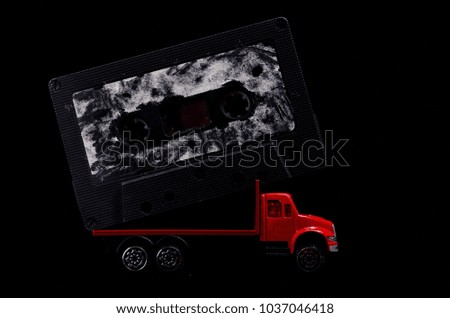 Music Concept Red Truck and Audio Music Tape on a Black Background