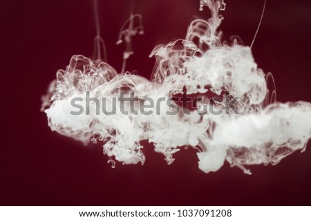 White ink dissolves in water on a black background