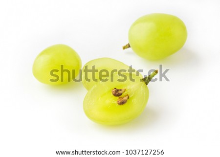 Goup of grape berries, one cuted in half on white background, view from above