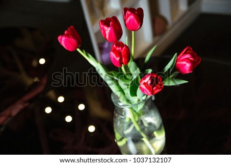 Bouquet of tulips in a transparent vase on a black table