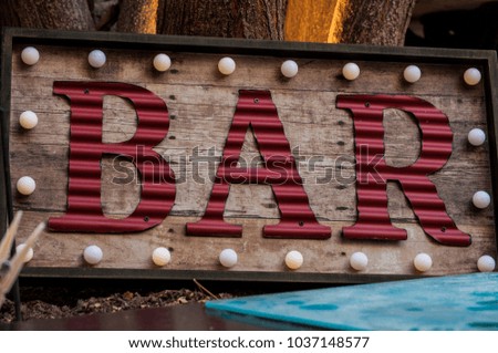 Vintage decorations: a neon sign of a bar with a frame of bulbs
