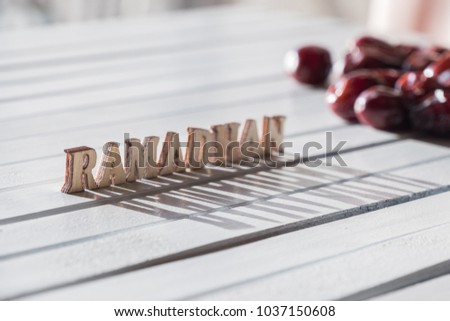 RAMADHAN text with dates fruit on wooden table top in the morning light