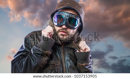 pilot of the 20s with sunglasses and vintage aviator helmet. Wears leather jacket, beard and expressive faces