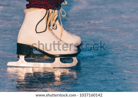 Close-up of woman skating on ice. Close-up of skates and ice. Beautiful winter day.