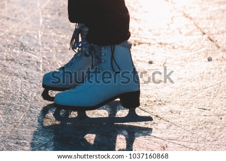 Close-up of woman skating on ice. Close-up of skates and ice. Beautiful winter day.
