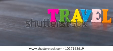 Colorful TRAVEL text on wooden table top