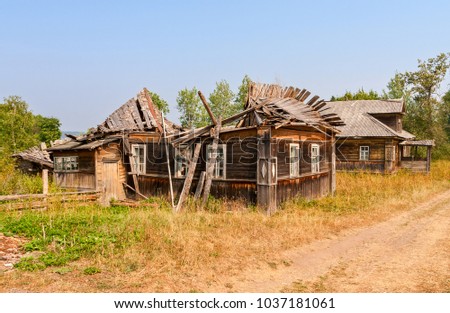 Old wooden broken houses in russian abandoned village in summer day. Novgorod region, Russia