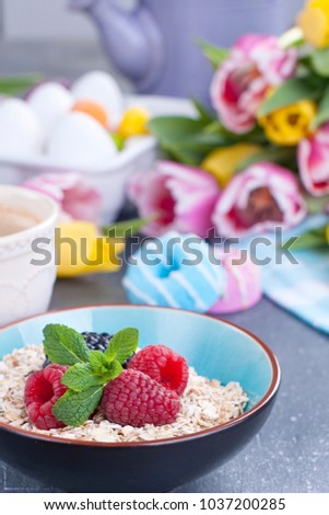 Oatmeal flakes with raspberries and mint and coffee. Spring tulips. Sweet breakfast and Easter decor. Free space for text.