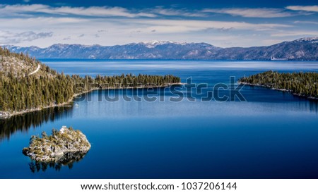 View of Lake Tahoe from near Emerald Bay, California, USA, including Fannette Island, in the end of the winter of 2018, covered with a very shallow layer of snow.  Royalty-Free Stock Photo #1037206144