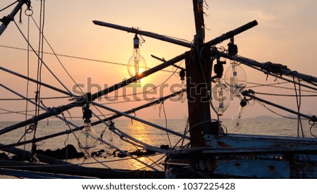 The Sunshine is in  light bulb to use for deceive the squid for fisherman at sunset. The Silhouette picture.    